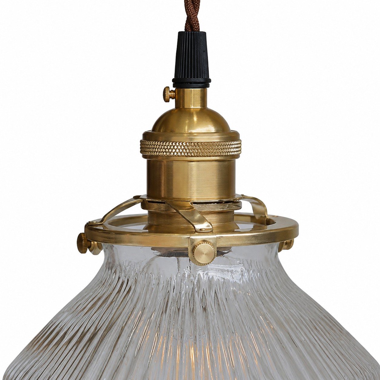 Close detail of ribbed transparent glass and brass pendant hardware
